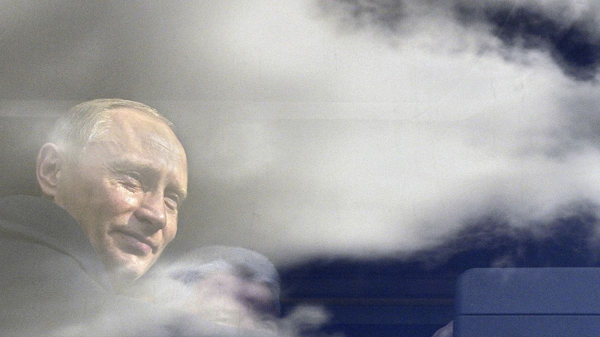 Russian President Vladimir Putin seen through a bus window, which reflects sky and clouds, during his visit to Kaliningrad in July 2005