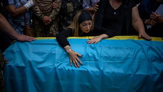 Anastasia Ohrimenko, 26, cries over her husband's coffin Yury Styglyuk, a Ukrainian serviceman who died in combat on August 24 in Maryinka, Donetsk, during his funeral.