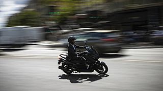 Un motorista circula con su moto por la ciudad