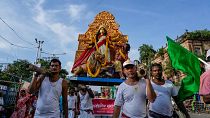 المشاركون يحملون معبودًا من الطين للإلهة الهندوسية دورجا على أكتافهم أثناء مشاركتهم في موكب للاحتفال باعتراف اليونسكو بدورغا بوجا، كولكاتا، الهند، الخميس 1 سبتمبر 2022