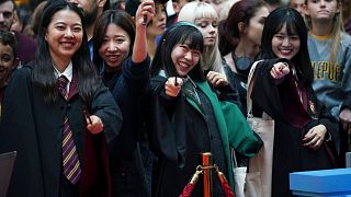Harry Potter fans pose for a photo at the Back to Hogwarts event, at King's Cross station in London, Thursday, Sept. 1, 2022