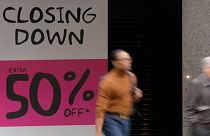 Shoppers pass a closing down shop in Oxford Street in London, Wednesday, April 13, 2022