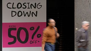 Shoppers pass a closing down shop in Oxford Street in London, Wednesday, April 13, 2022
