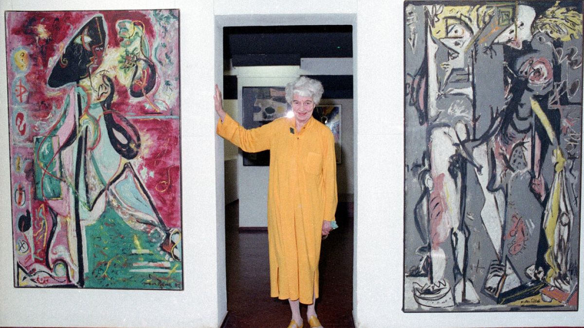 Peggy Guggenheim poses between early paintings by Jackson Pollock that are part of her modern art collection at her 18th century palace, Palazzo Venier dei Leoni, in Venice