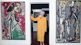 Peggy Guggenheim poses between early paintings by Jackson Pollock that are part of her modern art collection at her 18th century palace, Palazzo Venier dei Leoni, in Venice