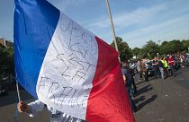 A taxi driver waves a French flag with inscription reading "Uber, here it's France" during a demonstration in Paris, Thursday, June 25, 2015 in Paris.