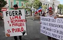 Dos manifestantes con pancartas en las protestas de este jueves en Puerto Rico