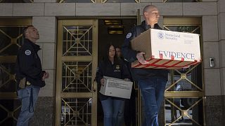 "Bizonyíték" feliratú dobozokat visznek el a rendőrök az ingatlanokból