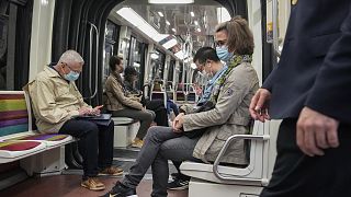 Maszkot viselő utasok a párizsi metrón