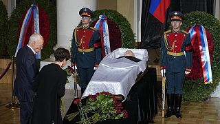 People stand by the coffin of former Soviet leader Mikhail Gorbachev inside the Pillar Hall of the House of the Unions during a farewell ceremony in Moscow, 3 September 2022