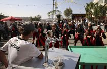 زائر يشاهد عرض راقصين فلسطينيين خلال مهرجان أكتوبر السنوي للبيرة في قرية طيبة في الضفة الغربية المحتلة. 2022/09/02