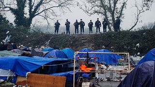 قوات الشرطة الفرنسية تراقب المخيم المؤقت للمهاجرين في غراند سينث ، شمال فرنسا - أرشيف