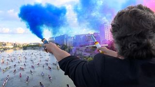 Woman lights a smoke bomb to launch the beginning of the Traversée de Paris and of the Hauts-de-Seine