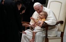 البابا فرانسيس يحتضن طفلاً في قاعة بول السادس بالفاتيكان، الأربعاء 31 أغسطس 2022