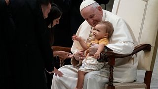 البابا فرانسيس يحتضن طفلاً في قاعة بول السادس بالفاتيكان، الأربعاء 31 أغسطس 2022