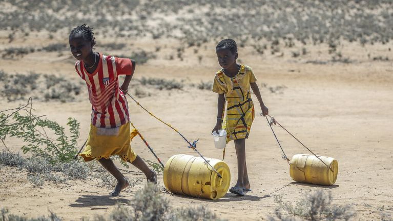 Des jeunes filles tirent des récipients d'eau d'un puits pour rentrer dans leurs huttes dans le village de Lomoputh, dans le nord du Kenya, 12 mai 2022. Des jeunes filles tirent des récipients d'eau d'un puits pour rentrer dans leurs huttes dans le village de Lomoputh, dans le nord du Kenya, 12 mai 2022.