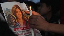 A Palestinian holds a picture of Shireen Abu Akleh during a candlelit vigil in Gaza.