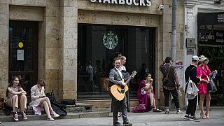 Fiatalok várakoznak egy bezárt Starbuck's kávézó előtt Moszkvában