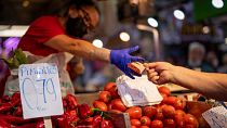 Покупатель расплачивается за овощи на рынке Маравильяс в Мадриде, май 2022 г.