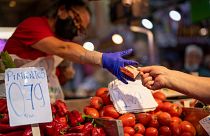 A customer pays for vegetables at the Maravillas market in Madrid, on May 12, 2022.