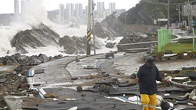 A road is damaged as waves hit a shore in Ulsan