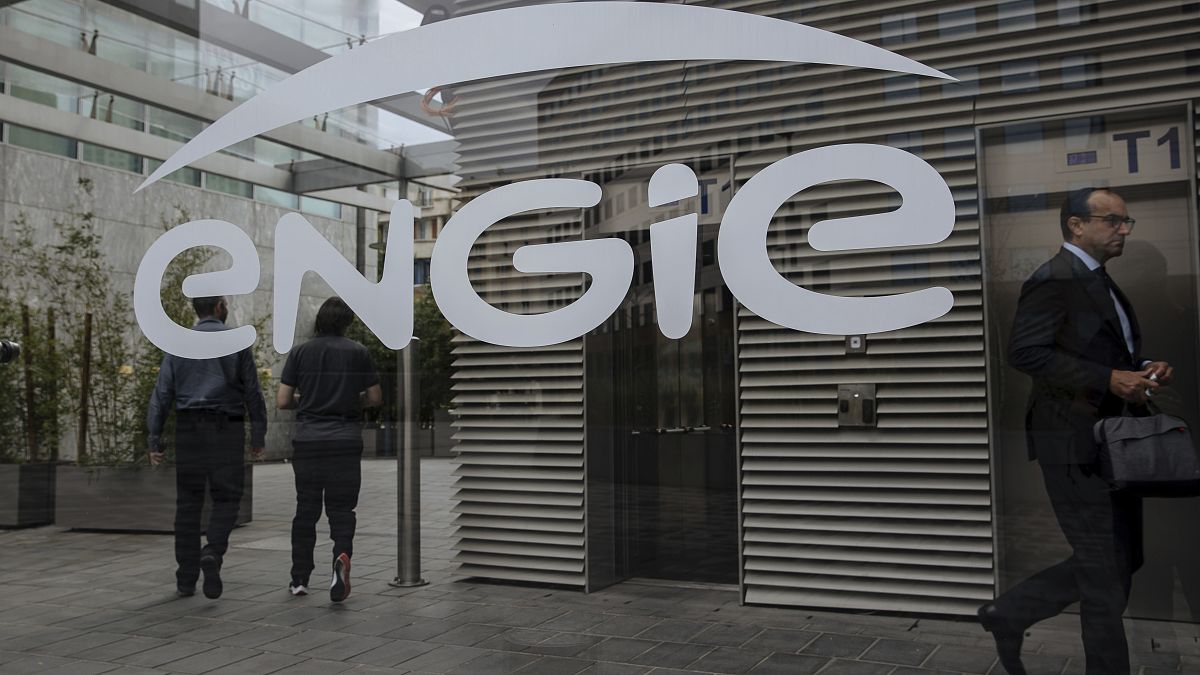 People walk in the lobby of the Engie headquarters, a group dealing with energy and services, in La Defense business district in Paris, Friday, Sept.2, 2022
