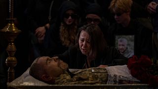 A relative cries next to the body of Viacheslav Nalyvaiko, a Ukrainian military officer killed during fighting against Russians, at his funeral in Kyiv 7 September 2022