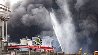 Firefighters spray water as black smoke comes out of chemical plant NitrolChimica.
