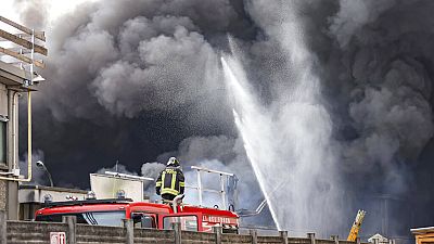 Firefighters spray water as black smoke comes out of chemical plant NitrolChimica.