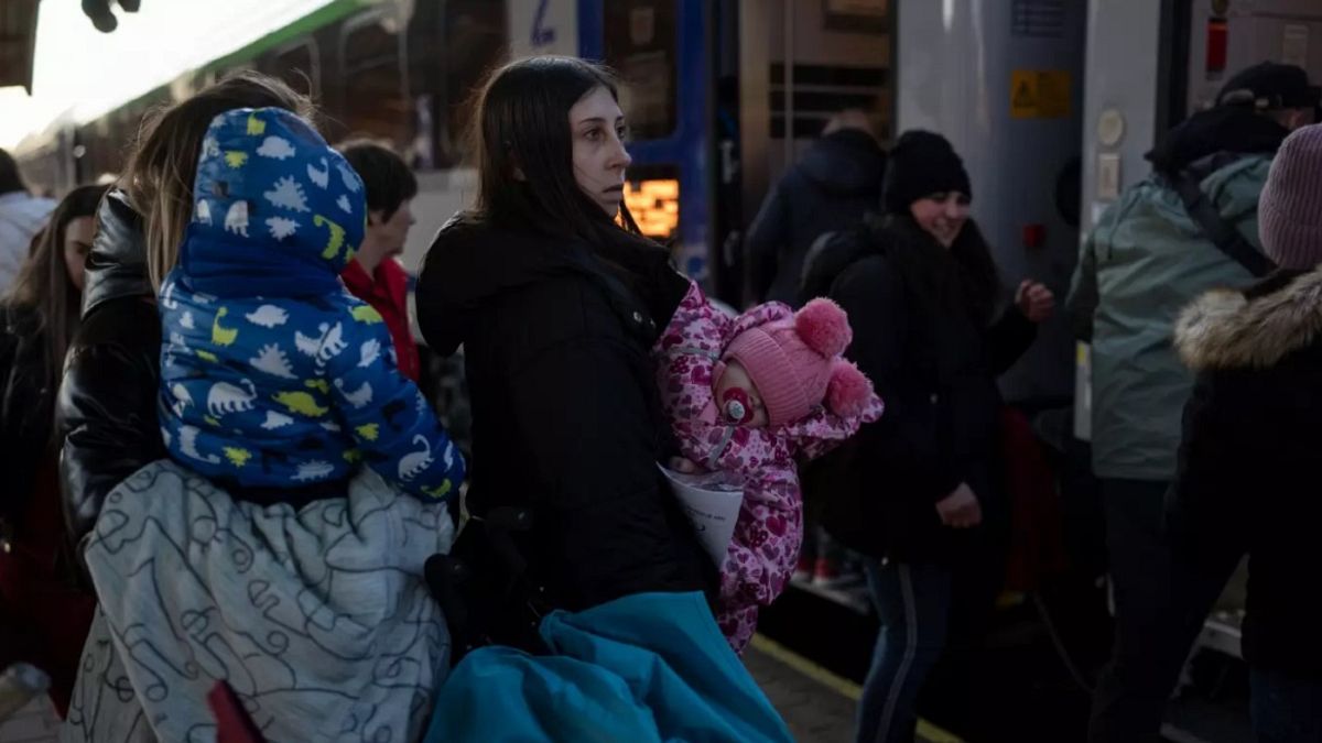 Polonya'nın güney batısında tren bekleyen bir Ukraynalı anne ve çocuğu (arşiv)