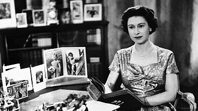 Queen Elizabeth II sits at desk at the royal country estate at Sandringham, England on 25 December 1957, shortly after delivering her first Christmas Day telecast.