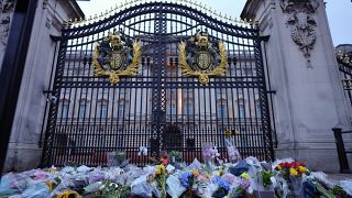 Подданные Великобритании оставляют цветы у ворот Букенгемского дворца в Лондоне