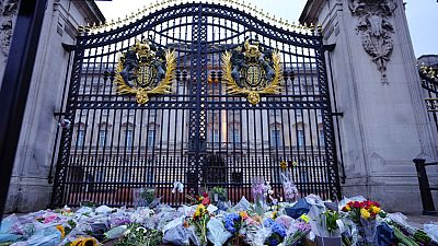 Des bouquets de fleurs déposés devant la grille du palais de Buckingham le 9 septembre 2022, au lendemain du décès de la reine Elizabeth II.