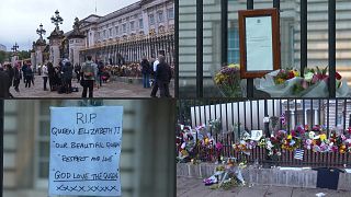 Emberek, virágok, üzenetek a Buckingham-palota kapujánál 2022. szeptember 9-én.