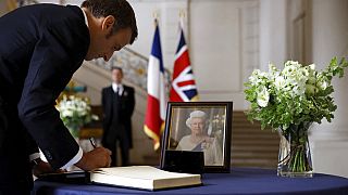 French President Emmanuel Macron signs a condolence book, following the passing of Britain's Queen Elizabeth, at the British Embassy in Paris, France