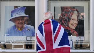 Un homme observe des portraits de la reine Elizabeth II dans une vitrine près du château de Windsor, en Angleterre, 9 septembre 2022.