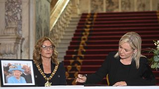 Sinn Fein Leader Michelle O'Neill, right, signs a Book of Condolence to mark the death of Queen Elizabeth II, at Belfast City Hall,