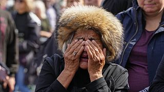 A mourner weeps as she pays respect to the Queen outside Buckingham Palace in London, Friday, Sept. 9, 2022.