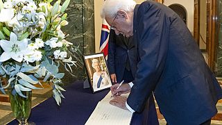 El presidente italiano, Sergio Mattarella, firma en el libro de condolencias.