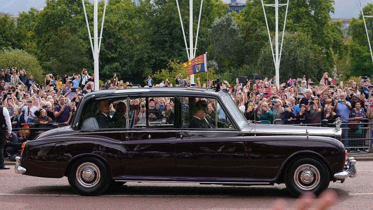 El rey Carlos III saluda a sus seguidores a su llegada al Palacio de Buckingham en Londres