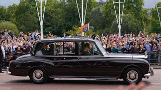 El rey Carlos III saluda a sus seguidores a su llegada al Palacio de Buckingham en Londres