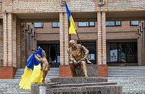 Une photo prise le 10 septembre 2022. Des drapeaux ukrainiens sont placés sur des statues sur une place de Balaklia.