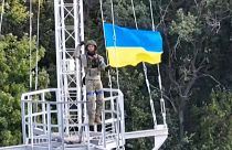 Un soldat ukrainien brandit un drapeau dans la région de Kharkiv