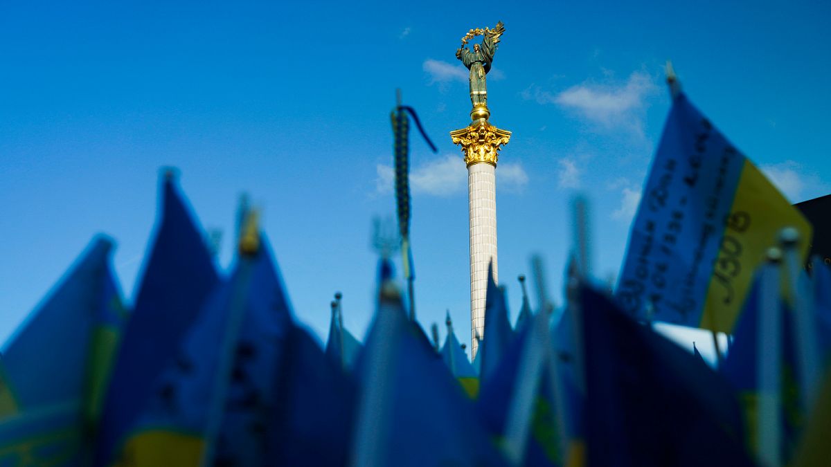 Bandeiras ucranianas sob o monumento da independência em Kiev