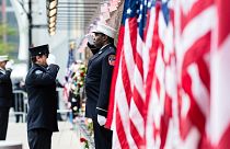Firefighters salute each other outside the FDNY Engine 10, Ladder 10 fire station near the commemoration ceremony of the September 11, 2001 terror attacks.