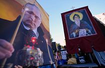 متظاهرون يحملون صورة للرئيس الروسي فلاديمير بوتين خلال مسيرة مناهضة لفعاليات مجتمع الميم الأوروبية، في بلغراد، صربيا
