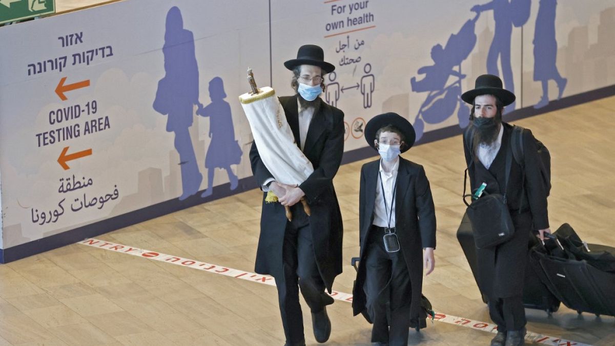 Ультраортодоксальные евреи прибывают в израильский аэропорт Бен-Гурион 9 сентября 2021 года после празднования Рош ха-Шана в Умани и паломничества к могиле раввина Нахмана