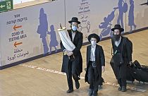Ультраортодоксальные евреи прибывают в израильский аэропорт Бен-Гурион 9 сентября 2021 года после празднования Рош ха-Шана в Умани и паломничества к могиле раввина Нахмана