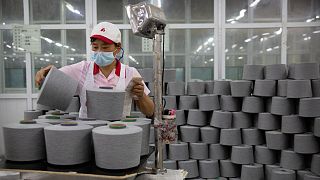 A worker packages spools of cotton yarn at a plant, as seen during a government trip for foreign journalists, in Aksu in western China's Xinjiang Uyghur Autonomous Region