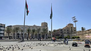 شبان يطعمون الحمام في ساحة الشهداء في وسط العاصمة طرابلس في 29 أغسطس 2022.
